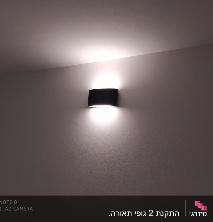 מנורת קיר דולקת על קיר לבן